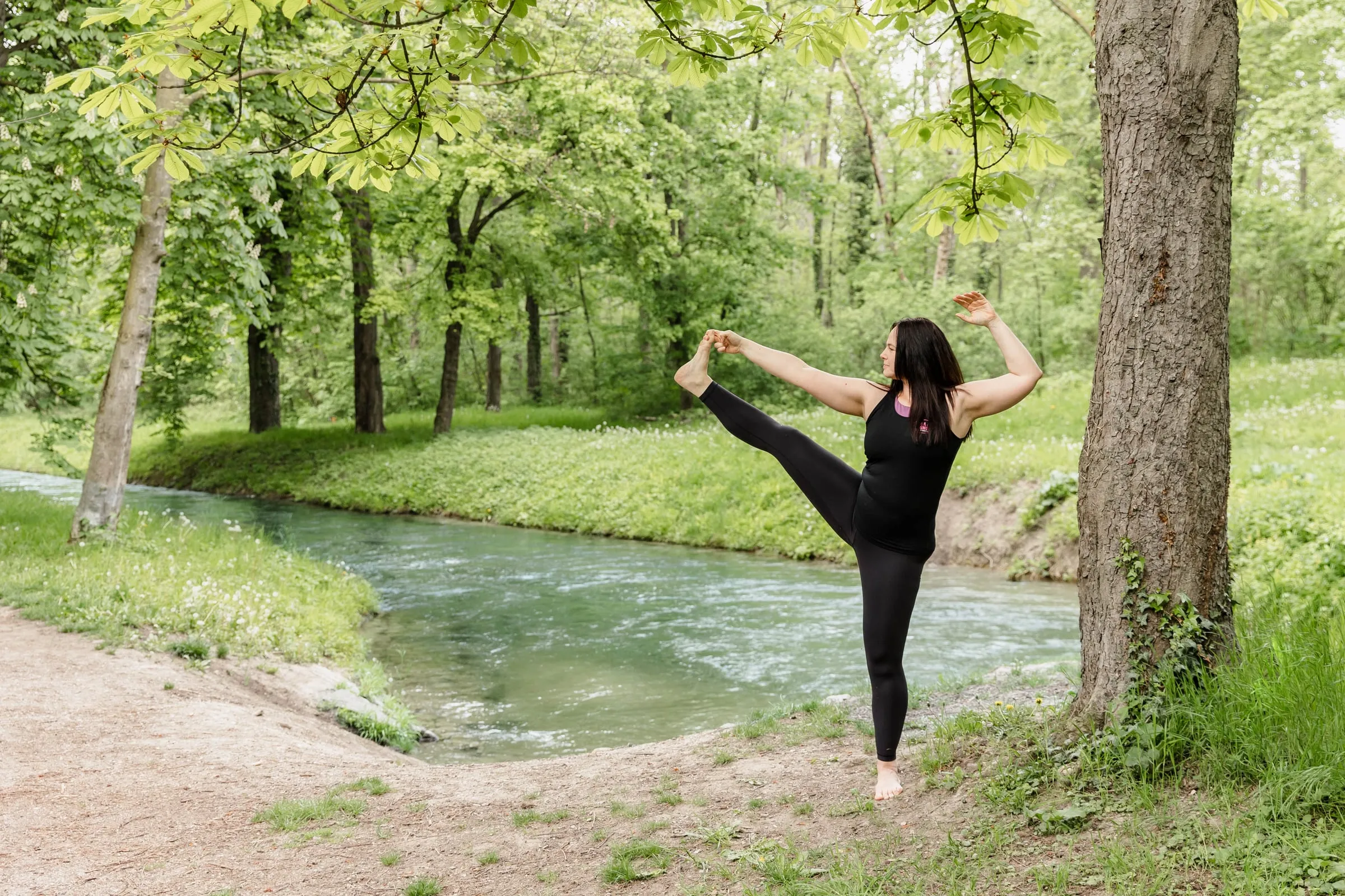 Madlen in einer stehenden Yogahaltung am Fluss