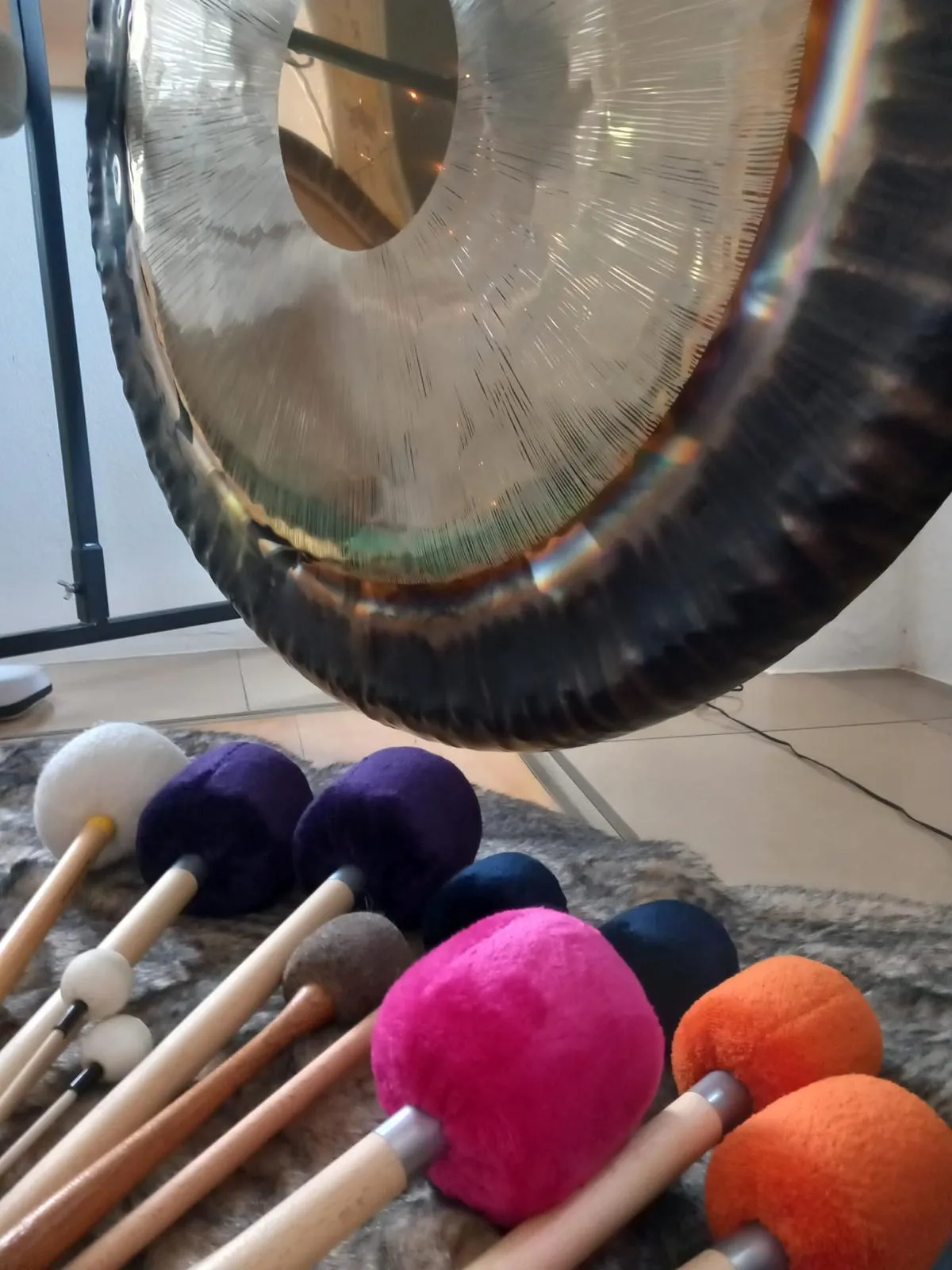 Gong mit bunten Schlägeln im Vordergrund