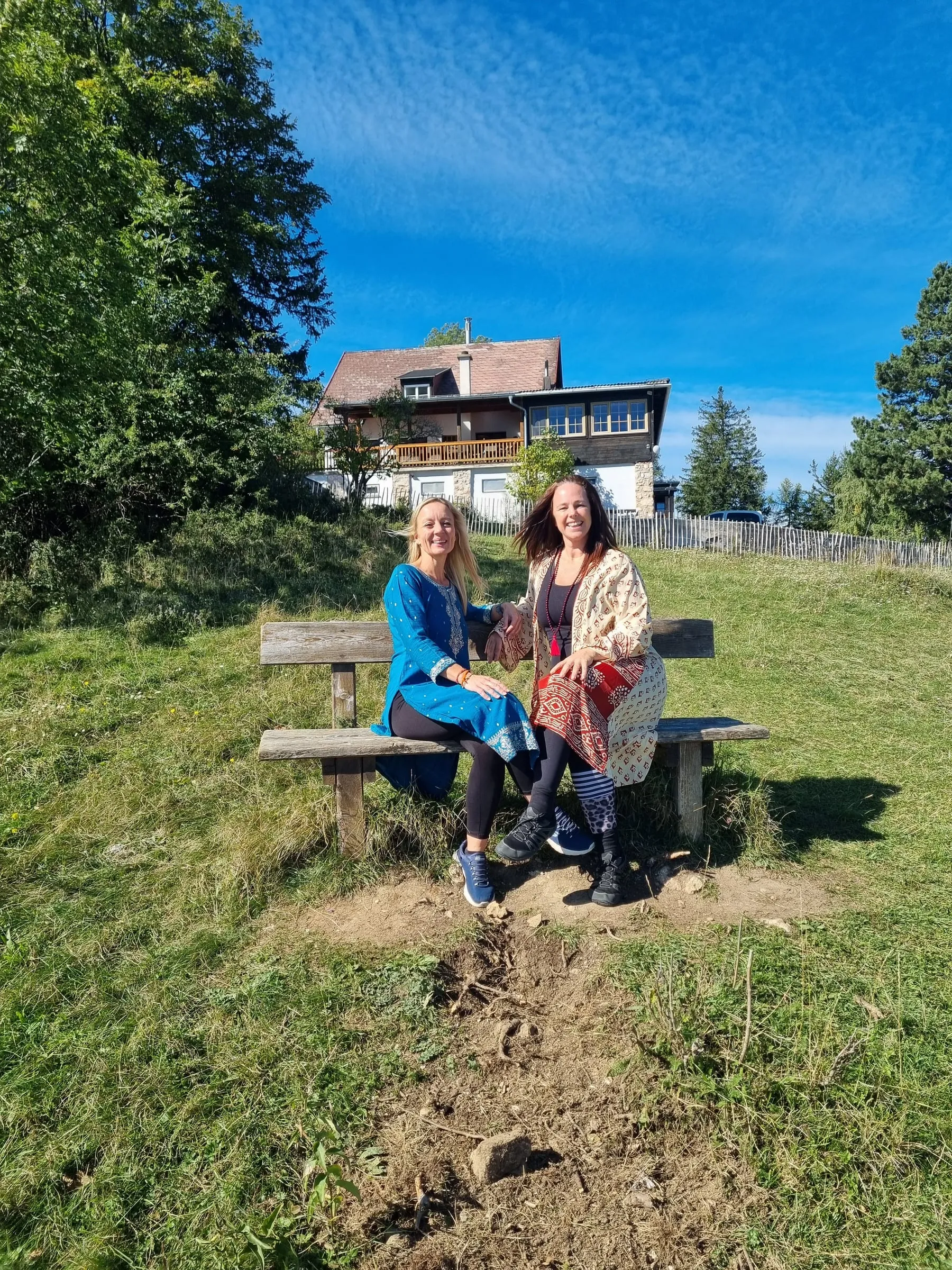 Madlen und Shakiri sitzen auf einer Bank vor dem Bergzendo