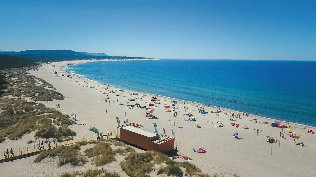 Weiter Sandstrand mit Dünen und blauem Meer