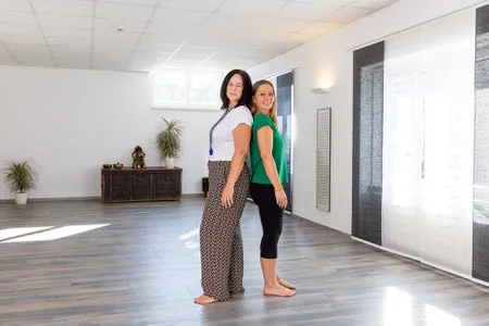 Madlen und Shakiri stehen in einem hellen Yogaraum